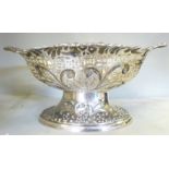 An Edwardian silver oval basket, embossed and pierced with berries, masks,