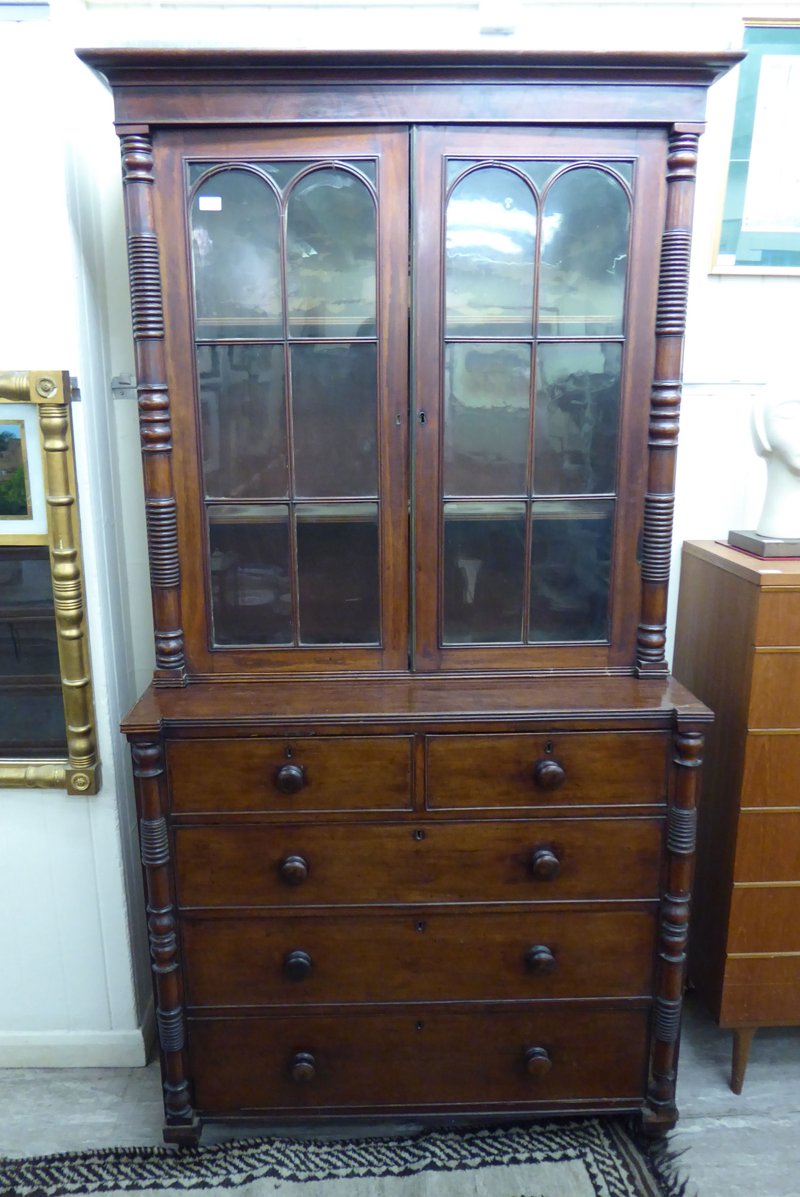 A William IV mahogany cabinet bookcase, the upper part enclosed by a pair of glazed panelled doors,
