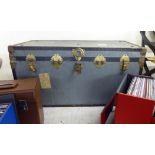 An early/mid 20thC grey coloured, metal finished and card bound canvas trunk with a hinged lid,