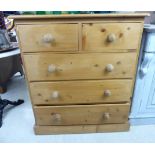 A modern waxed pine dressing chest, the two short/three graduated long drawers with bun handles,