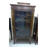 An Edwardian crossbanded mahogany display cabinet with a low upstand, an astragal glazed,