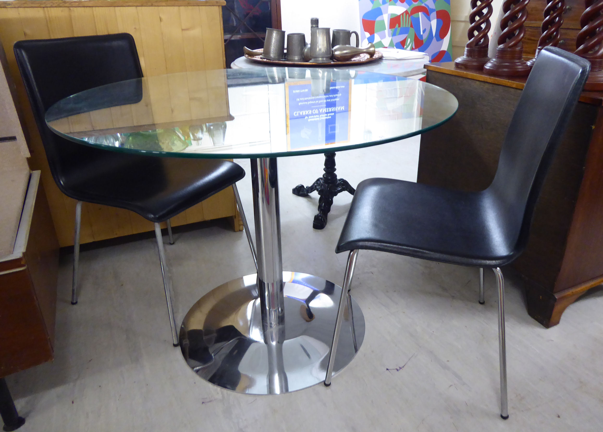 A modern breakfast table with a clear plate glass top, over a tubular,