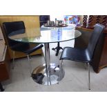 A modern breakfast table with a clear plate glass top, over a tubular,