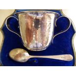 An early 20thC Arts & Crafts silver twin handled beaker cup with spot-hammered decoration;