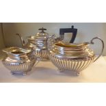 A matched three piece silver tea set comprising a teapot of oval,