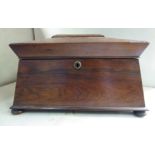 A Regency rosewood tea casket of sarcophagus form with flank ring handles,