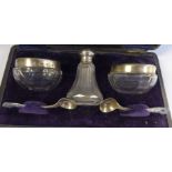 An Edwardian three piece facet cut glass and silver condiments set comprising a pair of salt
