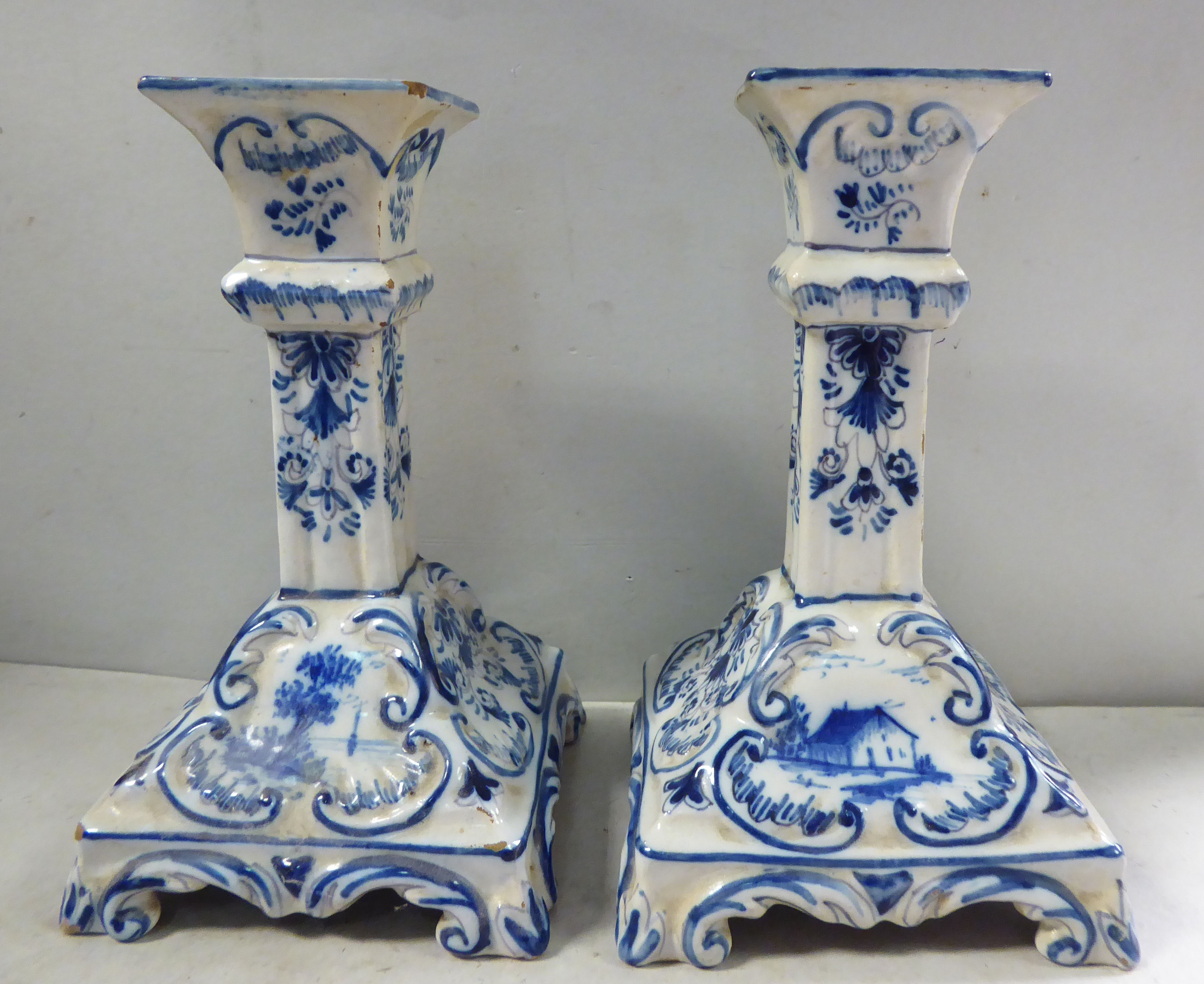 A pair of early Dutch Delft candlesticks, decorated in blue and white with flora and windmills 6.