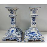 A pair of early Dutch Delft candlesticks, decorated in blue and white with flora and windmills 6.