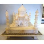 A late 19thC Indian carved alabaster model temple with a domed roof and corner minarets on a