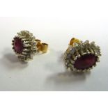 A pair of 18ct gold earrings, each set with a central oval ruby,
