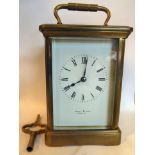 An early/mid 20thC lacquered brass cased carriage clock with bevelled glass panels and a folding