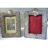 A pair of silver photograph frames, embossed with cartouches, foliate scrolls and flora,