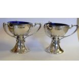 A pair of Edwardian silver salt cellars, each fashioned as a miniature, triple handled trophy cup,