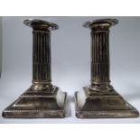 A pair of silver bead bordered dwarf candlesticks, each with a detachable sconce,