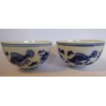 A pair of late 19th/early 20thC Japanese porcelain tea bowls, decorated in blue and white with carp,