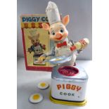 'Piggy Cook' a 'vintage' tinplate and plastic, clothed,