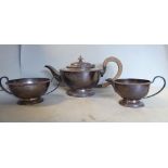 A three piece silver tea set of pedestal bowl design with gadrooned borders comprising a teapot