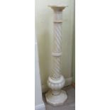 An early 20thC turned, wrythen carved, white alabaster pedestal,