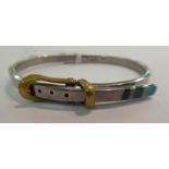 A buckled belt design, hinged silver bangle, set with turquoise,
