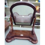 A late Victorian mahogany framed toilet mirror, pivoting on scrolled uprights,