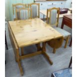 A modern honey coloured pine drop leaf breakfast table,