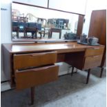 A 1960s Austinsuite, teak finished kneehole dressing table, surmounted by a rectangular mirror,