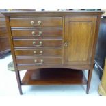 An Edwardian mahogany music cabinet with five fall-front drawers and lacquered brass bail handles