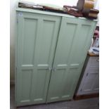 A modern green painted pine press cupboard with a low galleried upstand,