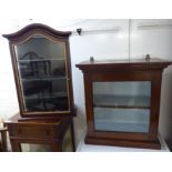 An early 20thC mahogany hanging cabinet with a dentil moulded cornice, over a glazed door,