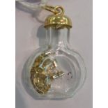 A yellow metal and glass miniature bottle pendant 11