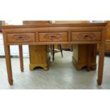 A modern Chinese hardwood panelled and mitred side table with three carved in-line drawers,