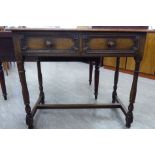 A mid 20thC stained oak hall table with two in-line drawers, raised on ring turned and block legs,