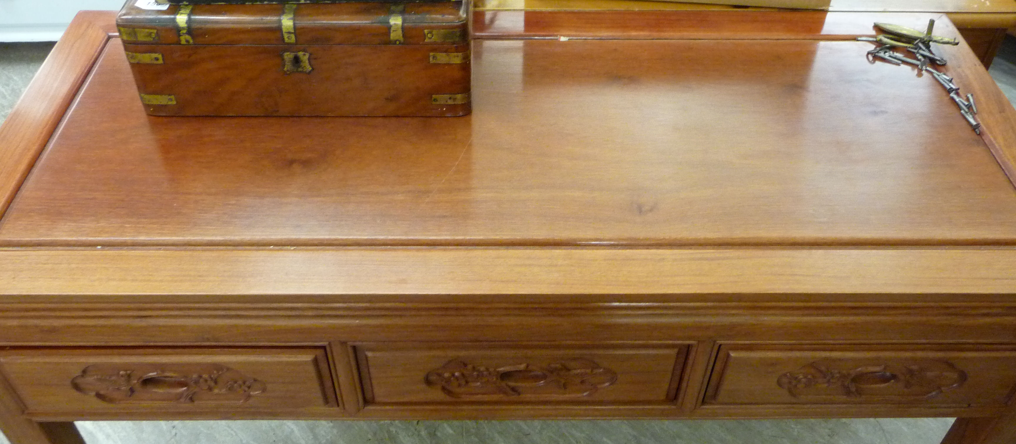 A modern Chinese hardwood panelled and mitred side table with three carved in-line drawers, - Image 2 of 2