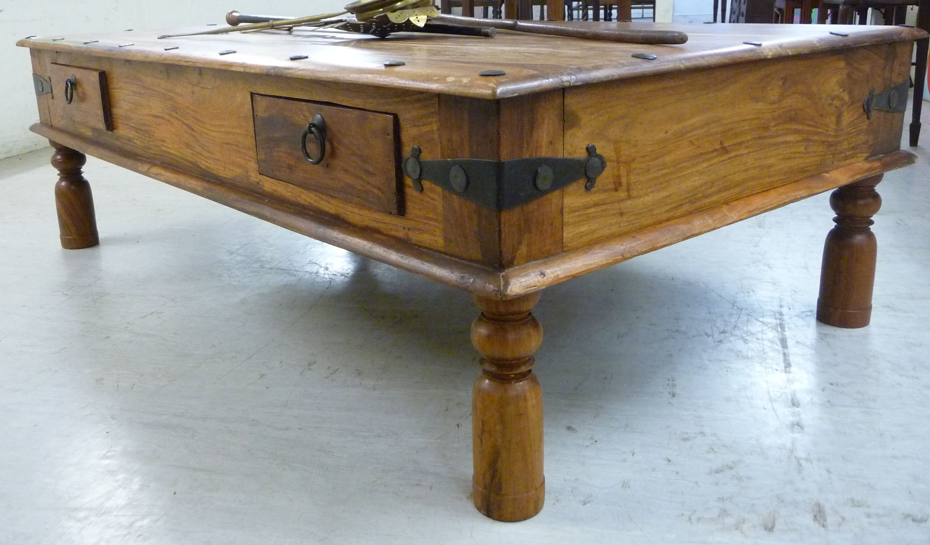 A modern Indonesian hardwood coffee table, over two frieze drawers with applied iron mounts,