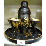 A 1930s Art Deco Japanese inspired black lacquered and gilt painted cocktail set comprising a tray