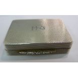 A silver pill box of rectangular form with engine turned decoration and a diagonal yellow metal
