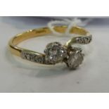An 18ct gold two stone diamond ring in a crossover setting 11