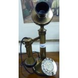 A lacquered brass candlestick design telephone with a modern plug CA