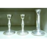 A pair of loaded silver candlesticks, each with a vase shaped socket, over a baluster stem,