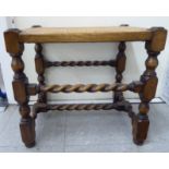 A 1930s stained beech framed stool with a woven split cane panelled top,