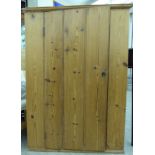 A late 19thC rustically constructed pine hanging corner cupboard with a tongued and grooved planked