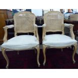 A pair of 20thC Louis XV limed beech framed open arm chairs with woven split cane panelled backs