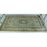 A Persian part silk woollen rug with stylised flora on a cream coloured ground 36'' x 62''