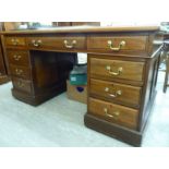 An early 20thC mahogany nine drawer twin pedestal desk,