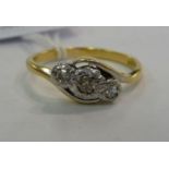 An 18ct gold three stone crossover set diamond ring 11