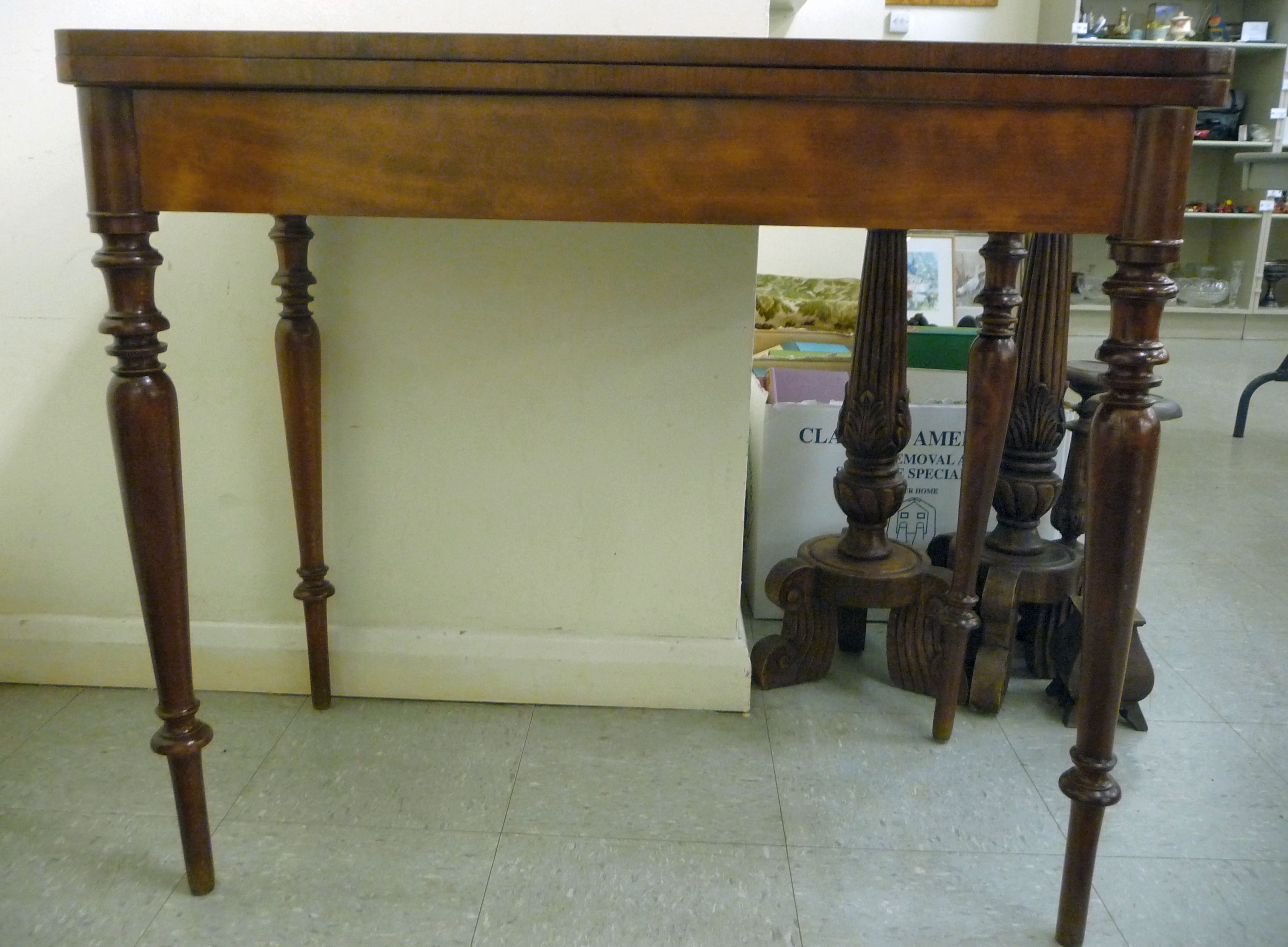 An early 19thC mahogany tea table with a rotating foldover top, raised on ring turned,