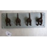 A novelty coat rack, fashioned as four dogs' tails,