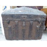 A late 19thC brown hide and metal clad trunk with a domed hinged lid and strapwork reinforcement