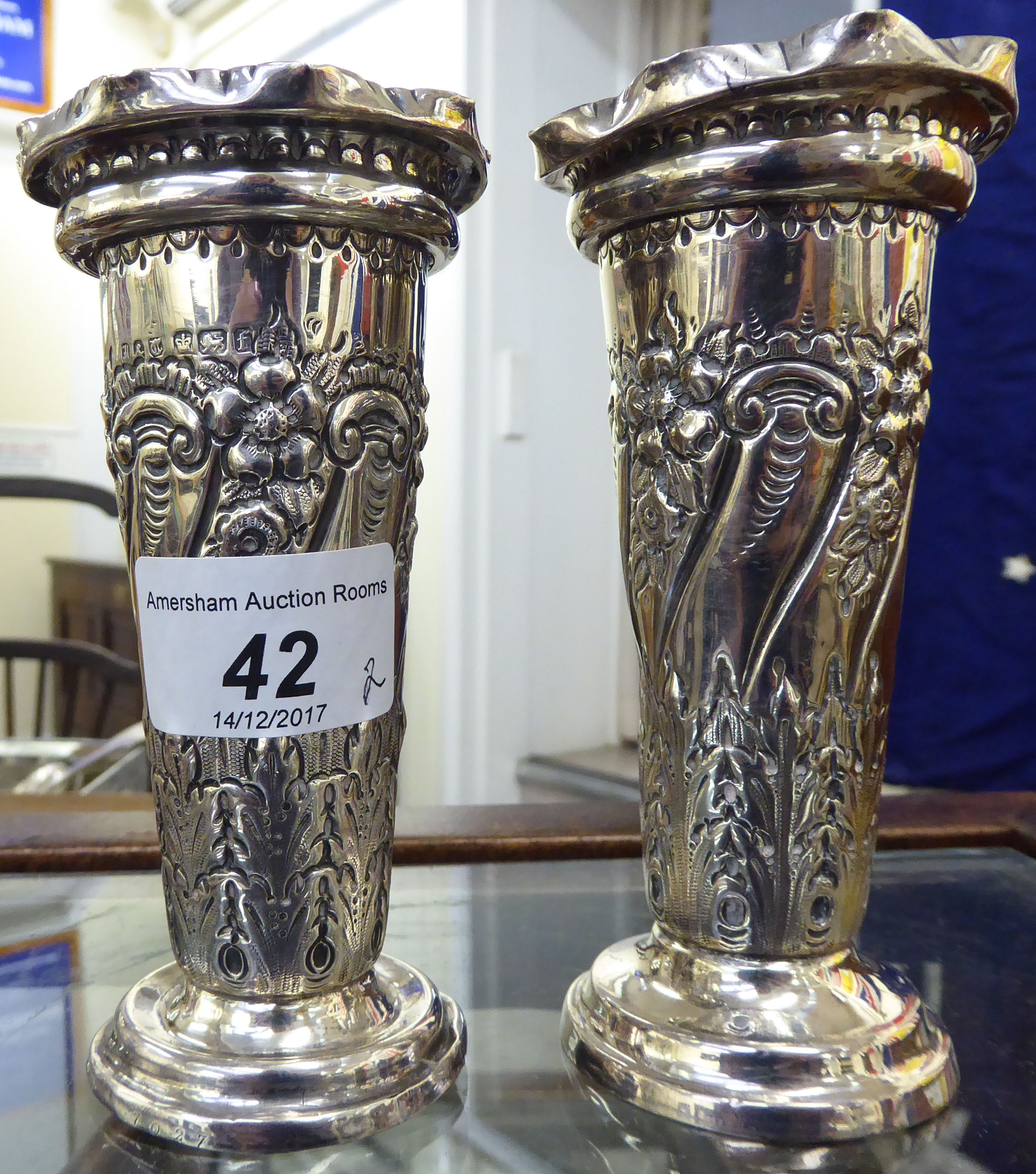 A pair of late Victorian silver specimen vases of trumpet design with embossed swag decoration